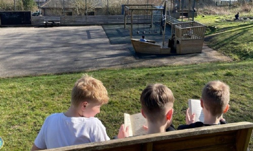 Bradwell students reading on a bench in the playground